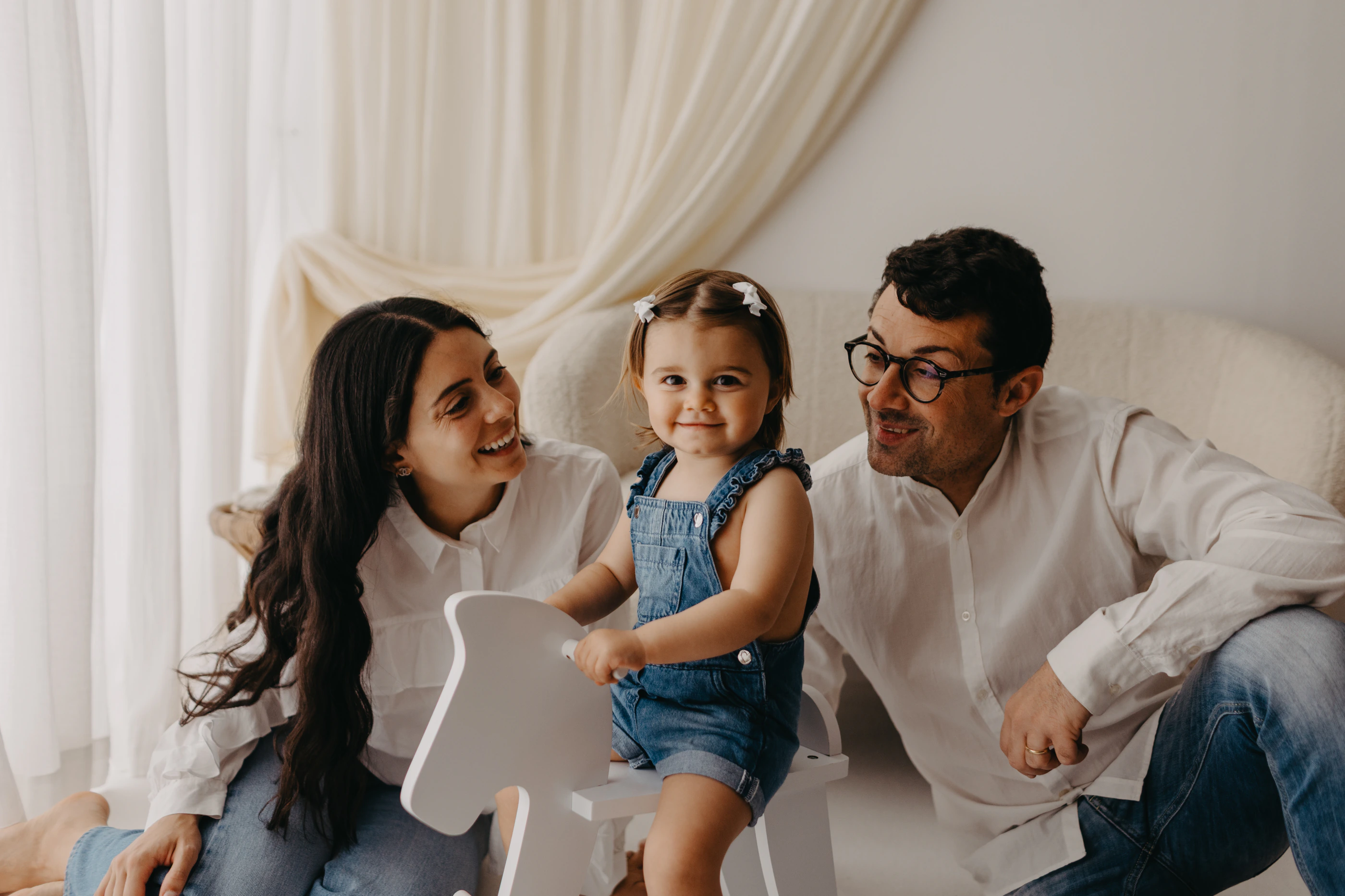 Famiglia seduta insieme mentre la bambina gioca