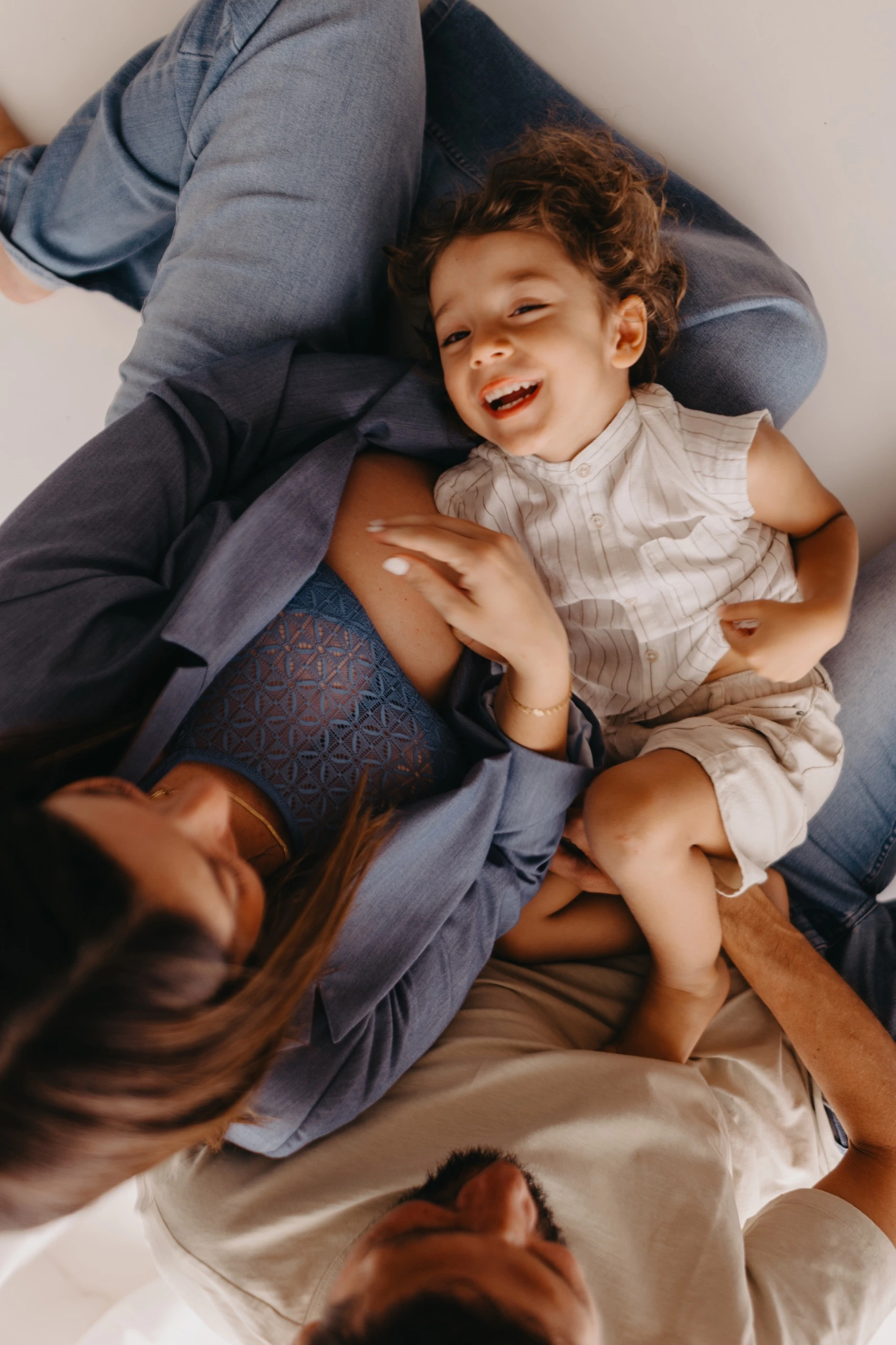 Famiglia distesa insieme mentre il bambino ride