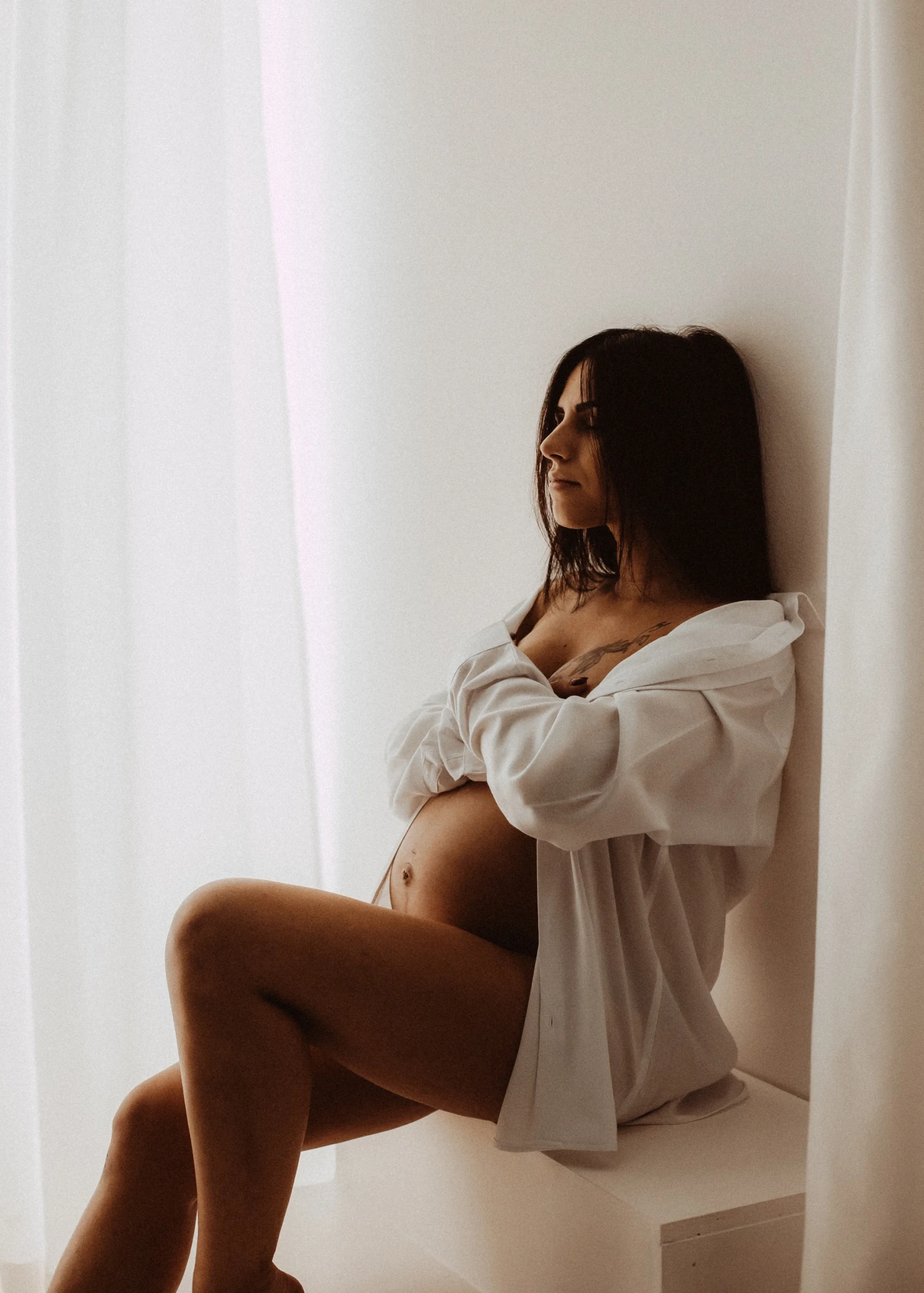 Ritratto di una donna in gravidanza in luce naturale